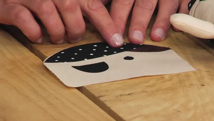 Stitch appliques: Stitch the appliques onto the doll's face and hat using a sewing machine or by hand.