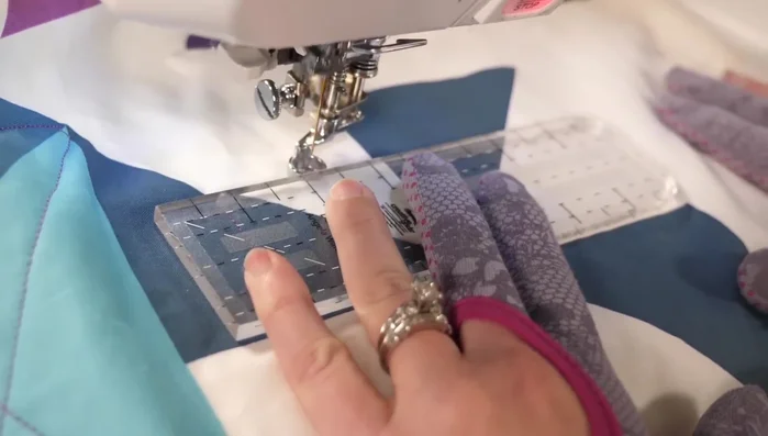 Quilt a small square inside the pinwheel, starting about an inch from the edge and following the seams as guides.