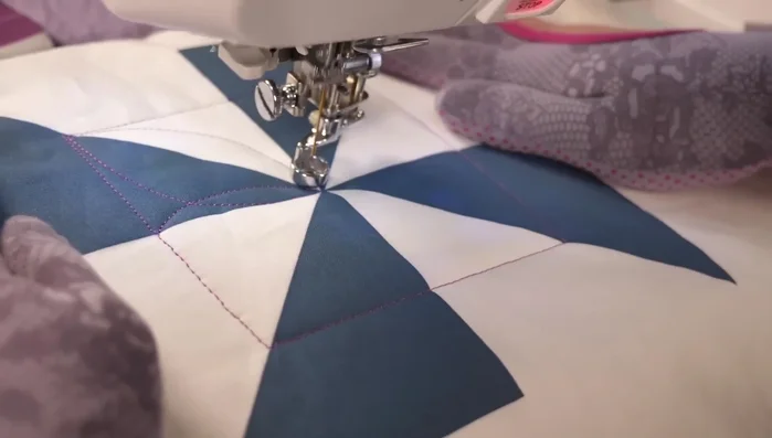 Quilt a continuous curve design within the inner pinwheel, creating a circular pattern.