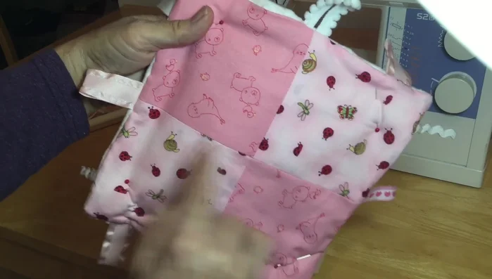 Stitch in the ditch to close the opening, securing rattles.