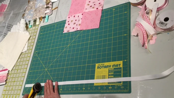 Pin ribbons to the edges of the fabric top, leaving approximately ¼ inch of overhang.