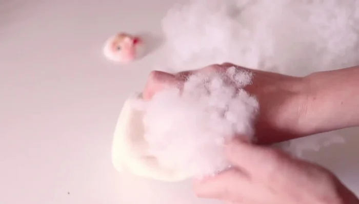 Stuffing the doll body.