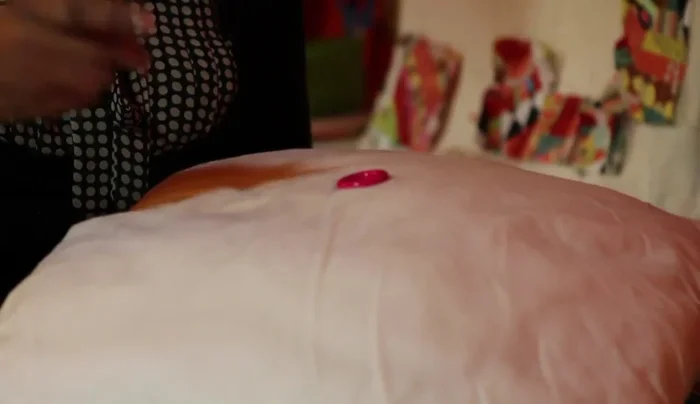 Go into one of the other button holes. Push the needle through to the other side, repeating this a couple of times to secure the loop.