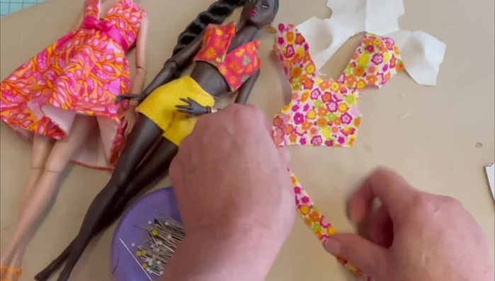 Attach ruffle to neckline: Pin center back of ruffle to center back of top, pull gathers to match neckline, and baste along the raw edge.