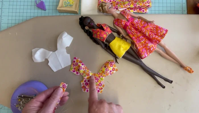 Attach ruffle to neckline: Pin center back of ruffle to center back of top, pull gathers to match neckline, and baste along the raw edge.