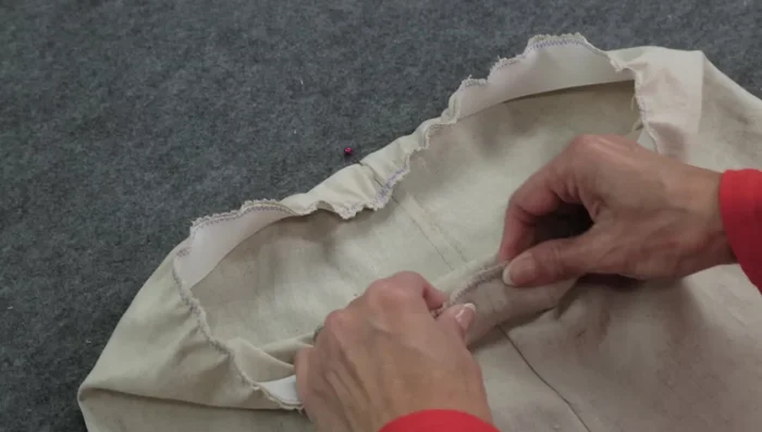 Fold the elastic to the wrong side, pin, and stitch the bottom edge of the elastic to the fabric with a wider zigzag stitch (1.8 length, 4.5 width), stretching the elastic as you sew.