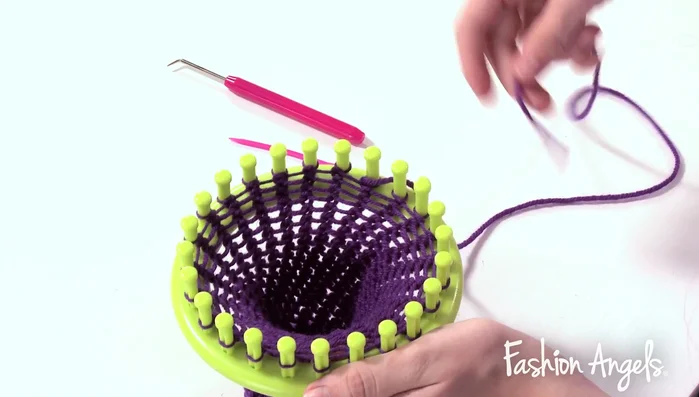 Remove the headband from the loom by using the needle to pull loops off the pegs.