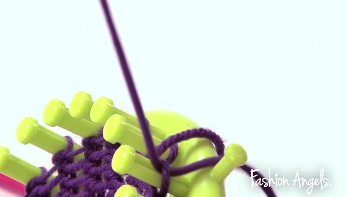 Remove the headband from the loom by using the needle to pull loops off the pegs.
