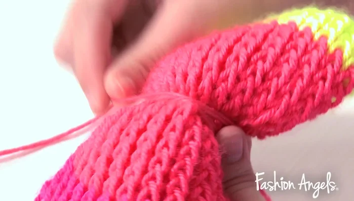 Wrap excess coral yarn around the center of the bow and tie it securely.