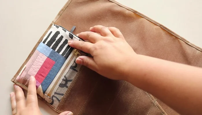 Load and finish: Load tools and roll the tool roll. Wrap and secure the leather cord.