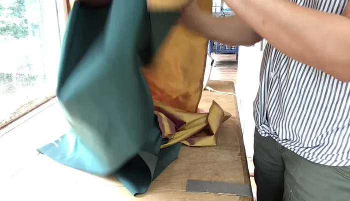 Fold the skirt and outside back panels, pressing to create neat corners. Ensure the main fabric is facing outwards, concealing the liner.