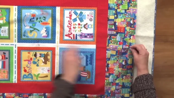 Align and pin the sides: Align a fold on one side of the quilt top with the corresponding crease on the backing. Pin to secure. Repeat on the opposite side.