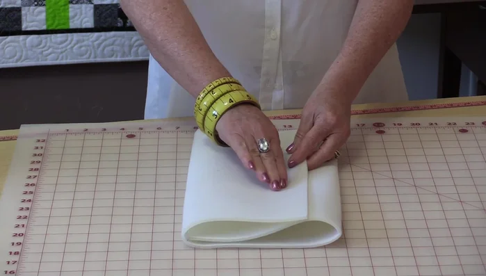 Add darts to the bottom corners of the bag body for shaping. Draw a 1-inch square in each corner, then draw a 45° angle line from the corner to a point on the square. Extend a line from the curve to 1.5 inches and connect it to the 1-inch mark.