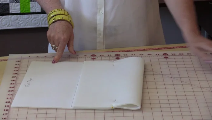 Add darts to the bottom corners of the bag body for shaping. Draw a 1-inch square in each corner, then draw a 45° angle line from the corner to a point on the square. Extend a line from the curve to 1.5 inches and connect it to the 1-inch mark.