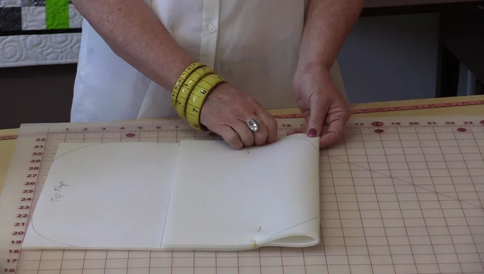 Add darts to the bottom corners of the bag body for shaping. Draw a 1-inch square in each corner, then draw a 45° angle line from the corner to a point on the square. Extend a line from the curve to 1.5 inches and connect it to the 1-inch mark.