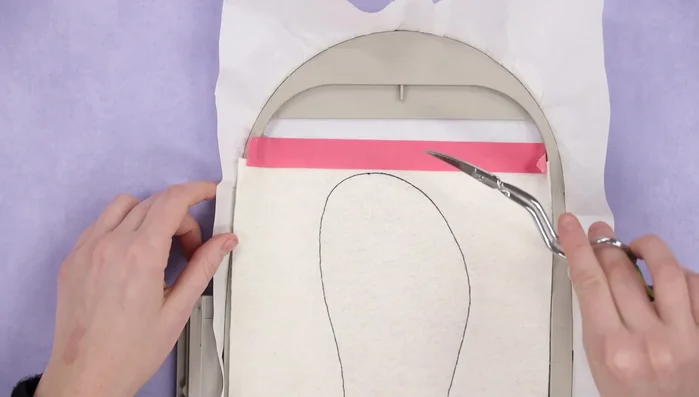 Place base fabric over the design, leaving seam allowance, and tape in place. Run the tacking stitch.