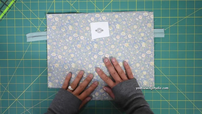 Baste stitch sides and bottom of the pocket (1/4 inch seam allowance). Trim excess zipper.