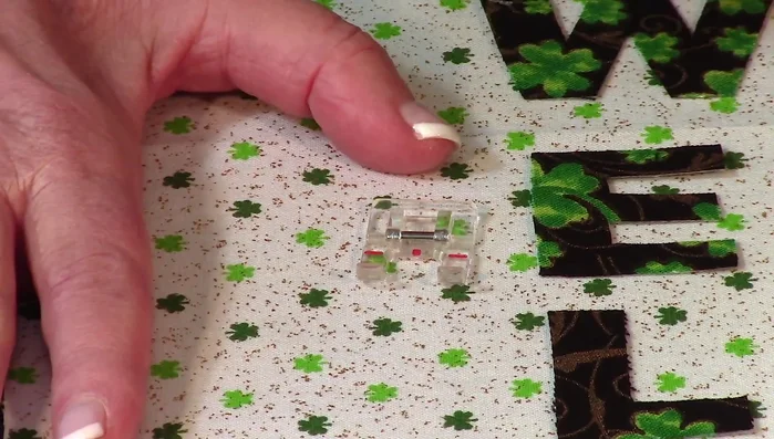 Stitch appliqués: Using an open-toe presser foot (recommended), stitch around each appliqué letter using a small satin stitch or zigzag stitch.