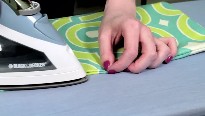 Iron the edges of the fabric under half an inch at the opening.