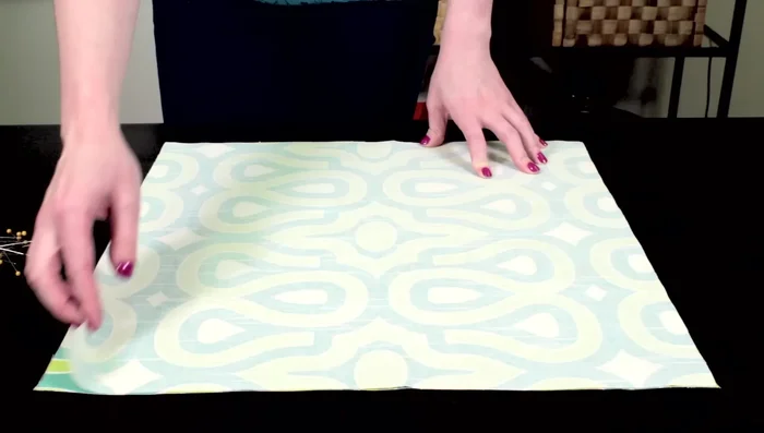 Align the two fabric squares with right sides facing and pin them together.