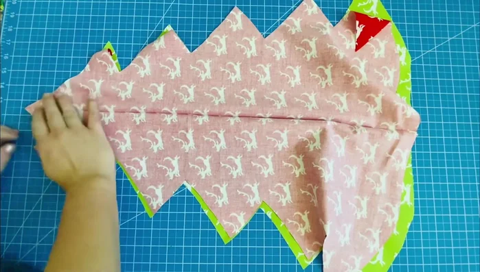 Sew tree sides: Place two fabric pieces right sides together, aligning from the tip. Pin or clip, and sew around, leaving a large opening at the bottom. Use the crease as a sewing guide. Leave the needle in the fabric, lift the presser foot, rotate, and continue sewing around corners.