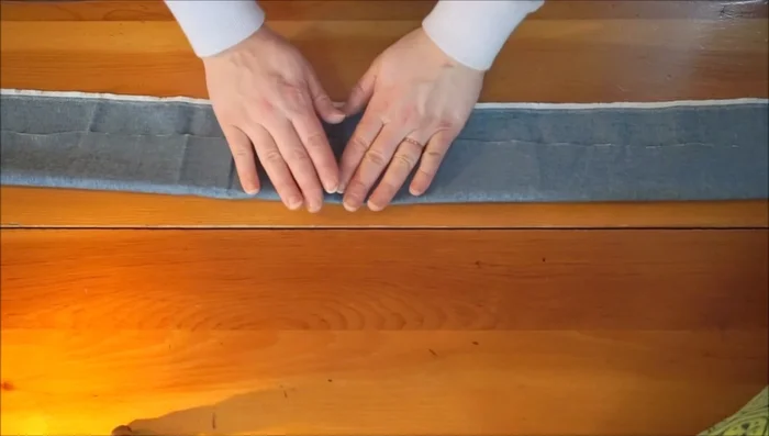 Position the strap and pin it to one side of the bag opening, ensuring it's not twisted.