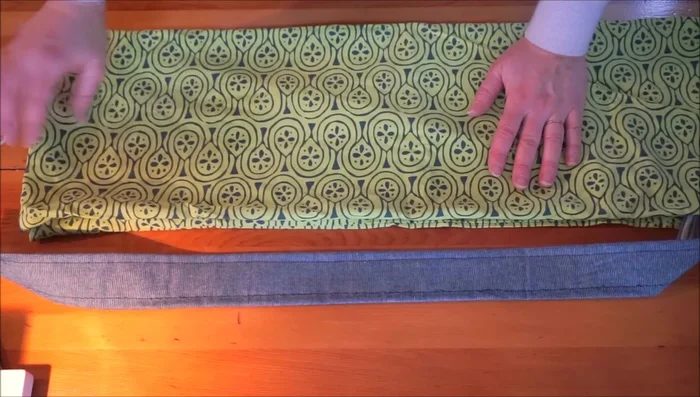 Position the strap and pin it to one side of the bag opening, ensuring it's not twisted.