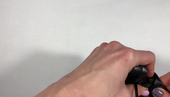 Thread the headband: Thread the headband through the hole, pass it under the knot, and insert it into the second hole.