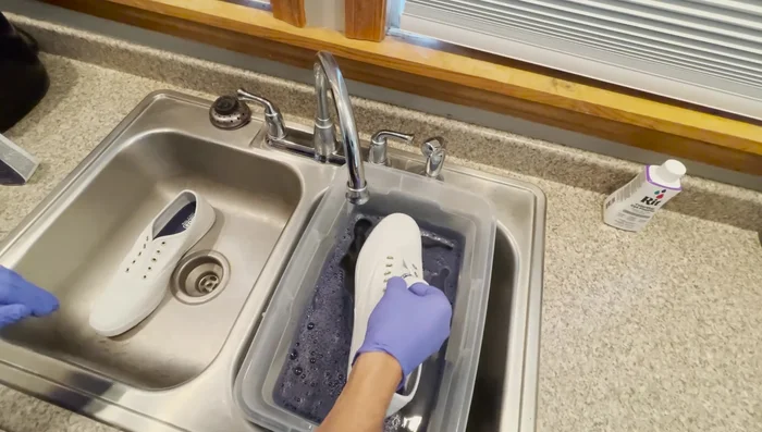 Dye the shoes: Submerge the shoes completely in the dye bath. Ensure the shoes are fully saturated.