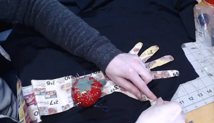 Cut out the glove shape, leaving the fingers connected. Don't cut between the fingers yet.