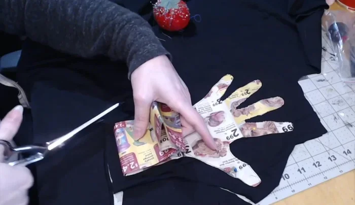 Cut out the glove shape, leaving the fingers connected. Don't cut between the fingers yet.