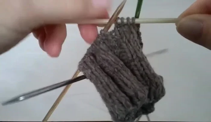 Place a marker on needle three, then slide two stitches from your working needle onto needle three.