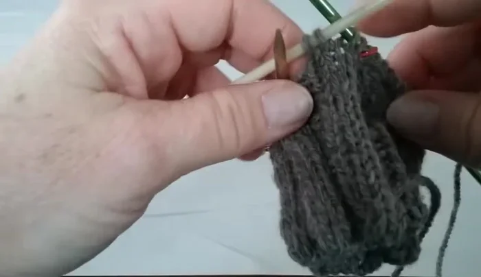Continue knitting your pattern, leaving the two stitches on needle three separate from the two on your working needle – this creates the thumbhole space.