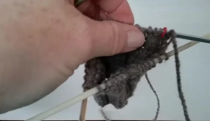 Continue knitting in the round on the inside until you reach the beginning of the thumbhole.