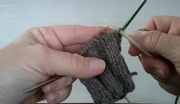 Place a marker on needle three, then slide two stitches from your working needle onto needle three.