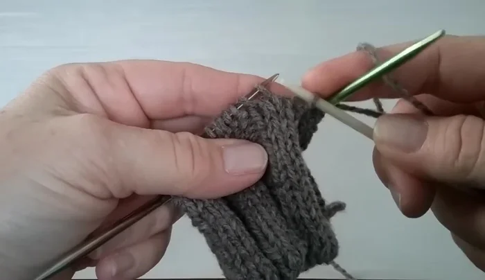 Place a marker on needle three, then slide two stitches from your working needle onto needle three.