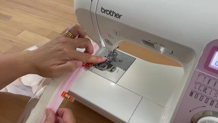 Sew the zipper: Using a zipper foot, sew along the edge of the zipper, close to the teeth, on one side of the zipper. Backstitch at the beginning and end.