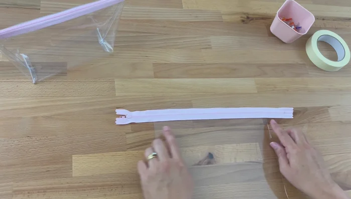 Sew the zipper: Using a zipper foot, sew along the edge of the zipper, close to the teeth, on one side of the zipper. Backstitch at the beginning and end.