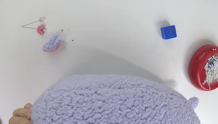 Attach ears to plush: Sew the ears to the plush head using either a whip stitch or a ladder stitch. Remove pins just before sewing to avoid catching them.