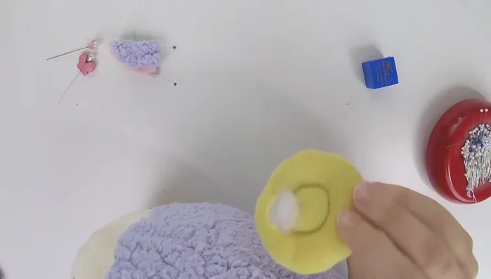 Optional: Add horns. If using horns, pin them to the desired location on the head, ensuring symmetry. Use a ladder stitch to sew the horns in a circle to the plush, securing the ears as well.