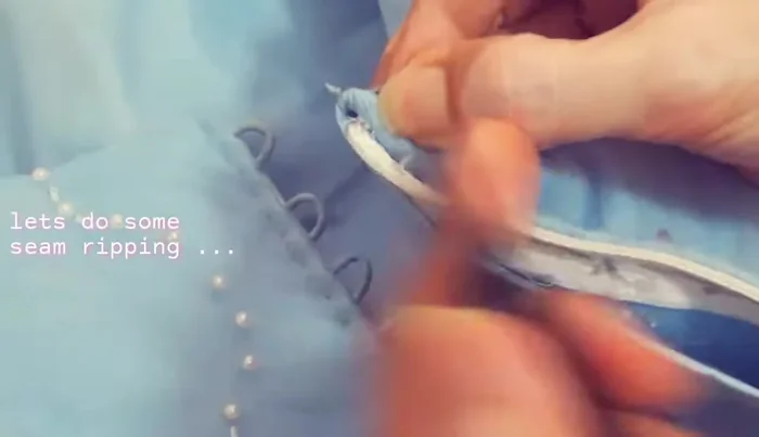 Remove the existing zipper. Hand stitch to secure the zipper tape.