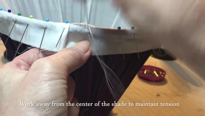 Work away from the center of the shade to secure the tension you have created in your pleats, gathers, or tailoring.