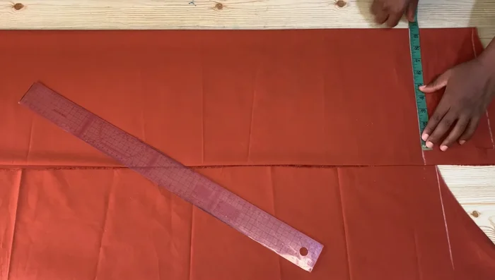 Measure and mark the sleeve length (20 inches + 1-inch seam allowance), armhole depth (7 inches), and wrist circumference (divided by two, plus seam allowance). Connect these points to complete the sleeve pattern.