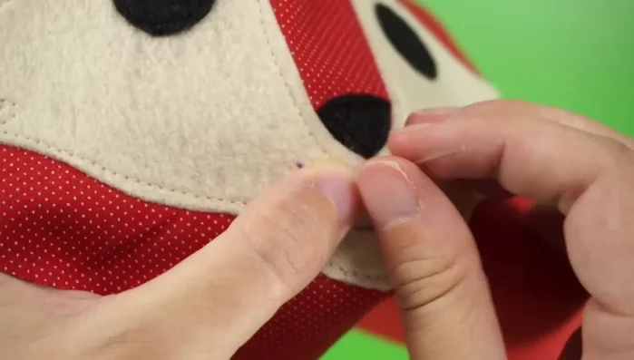 Embroider mouth: Draw the mouth and embroider it using a back stitch.