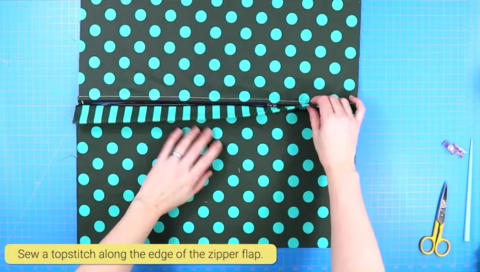 Finger press the seam open. Sew a top stitch along the top edge of the flap, moving the zipper head out of the way.