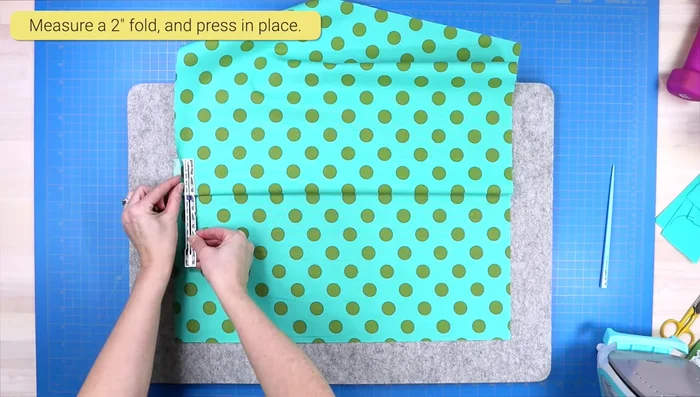 Create flap: Press a 2-inch fold over the zipper on the larger panel. Pin in place and sew across the top edge using a zipper foot.