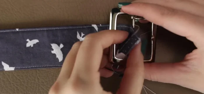 Slip the fabric through the buckle, then fold and hand-sew the raw edge onto the fold line.