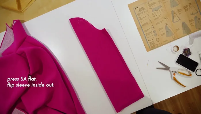 Clip corners and use a corner tool to sharpen them. Catch stitch and top stitch sleeve hem.