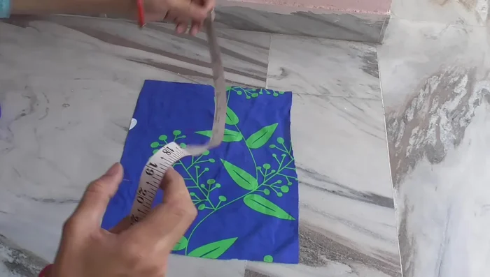 Make the flap. Cut a 15.5 inches x 19 inches rectangle. Fold and stitch the edges, then attach it to one side of the bag, aligning it with the top edges of the pockets.