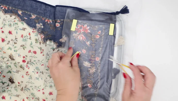 Remove the backing stabilizer: Carefully cut away as much of the mesh stabilizer as possible using duckbill scissors to avoid damaging the scarf. Wash away any remaining stabilizer.